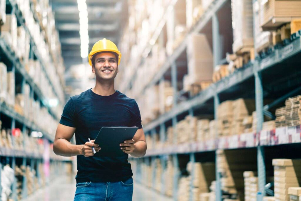 smart indian engineer man wearing safety helmet doing stock tick check cardboard stock product management factory warehouse background 1536x1025 1